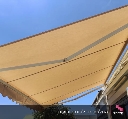 סוכך מותקן על מבנה עם שמיים כחולים